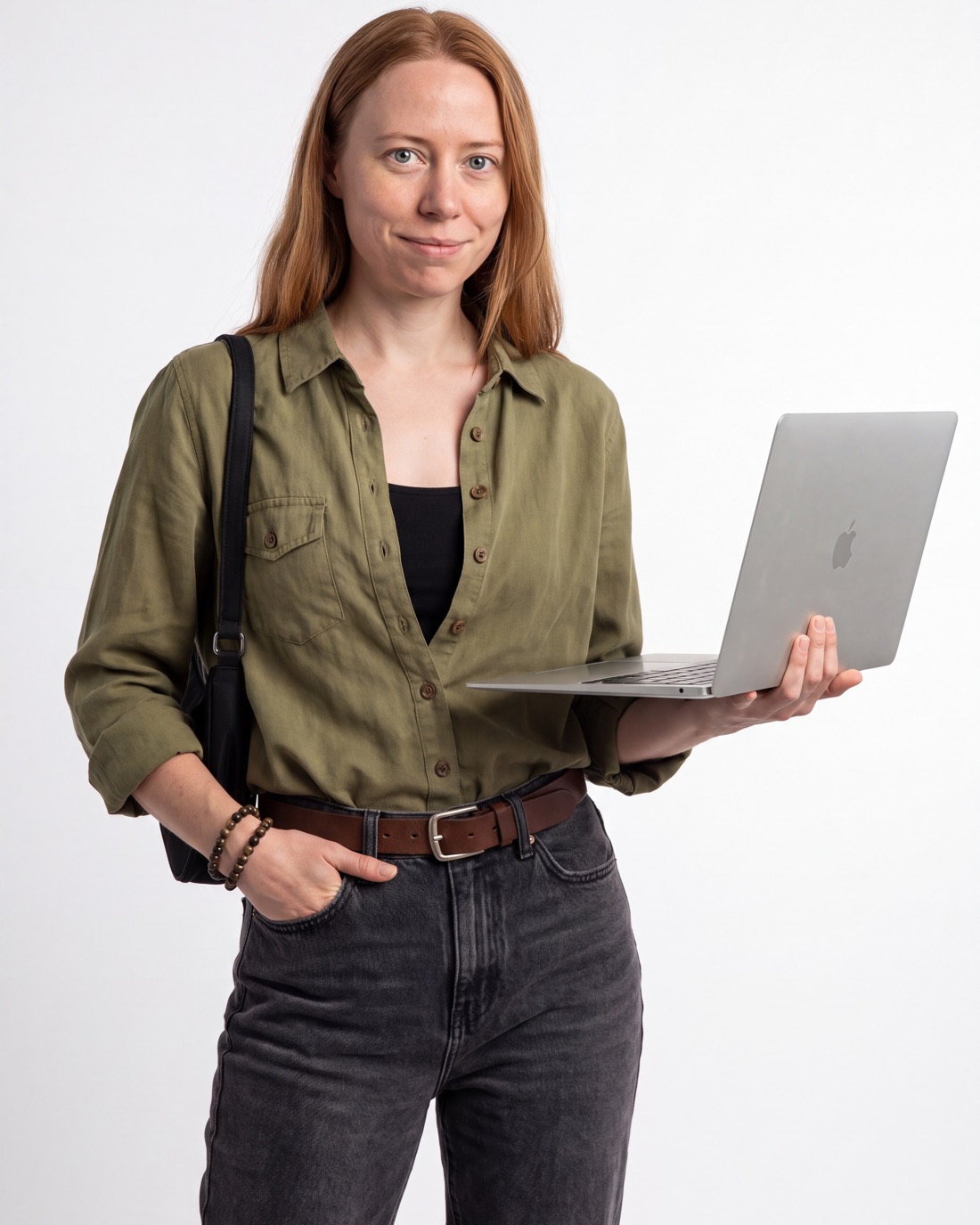 Eva Mryl, founder of Runina Creative, smiling and holding an open laptop in the studio