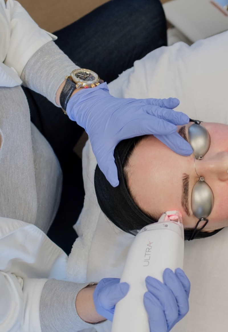 Laser skin treatment performed on a client wearing protective eyewear